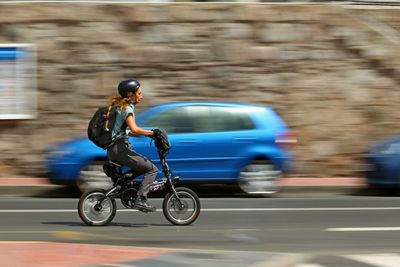 Side view of a man riding motorcycle on road