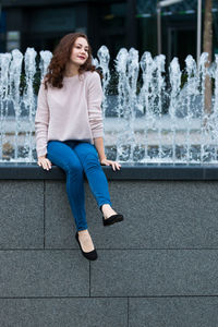 Smiling young woman sitting outdoors