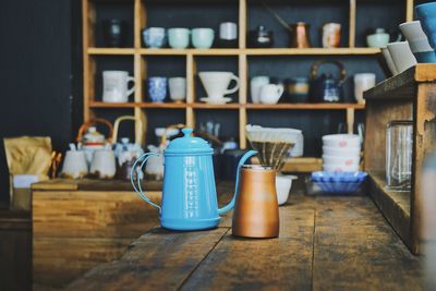 Kettle by container on table in cafe