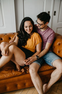 Young couple sitting on sofa at home