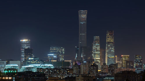 Illuminated buildings against sky at night