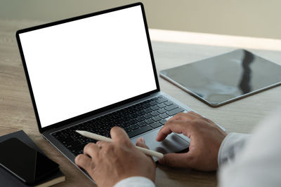 Cropped hands using laptop on table