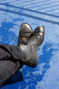 Low section of man with legs crossed at ankle