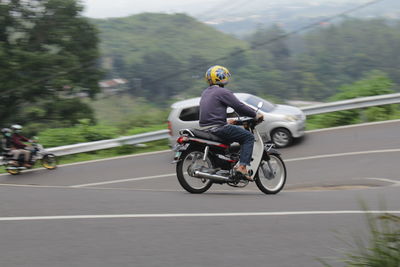 Man riding motorcycle on road