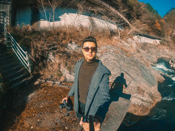 Portrait of young man standing on rock