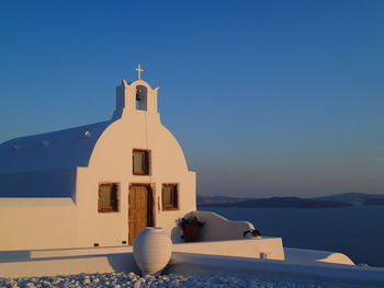 Church by building against clear blue sky