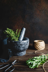 Close-up of mortar and pestle with herbs on table