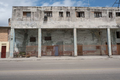 Old building by road against sky