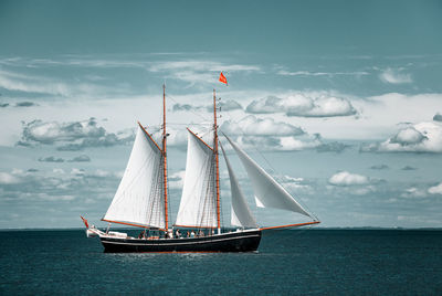 Sailboat sailing on sea against sky