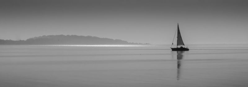 Panoramic view of boat sailing in sea against sky