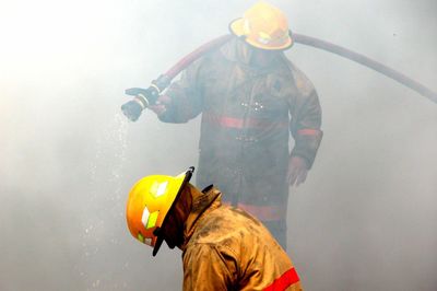 Firefighters with hose in smoke