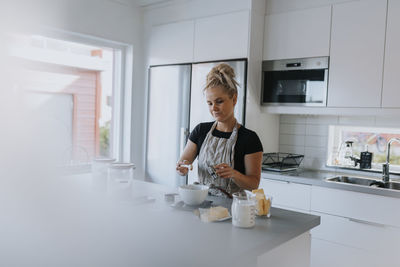 Young woman baking in kitchen