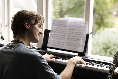 Passionate young man playing piano at home