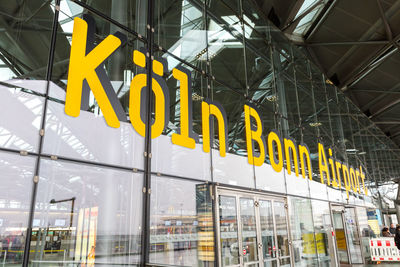 Low angle view of yellow sign on glass window