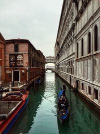 Canal amidst buildings against sky