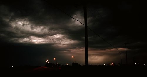 Low angle view of illuminated street light against cloudy sky