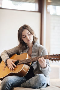 Teenage girl playing guitar