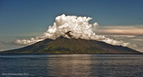 Scenic view of sea and mountains against sky