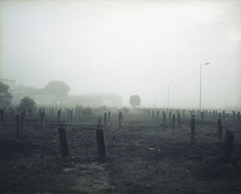 Wooden fence on field against sky