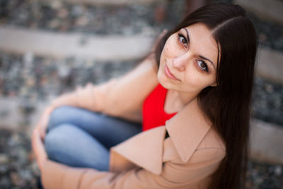 High angle portrait of woman sitting outdoors