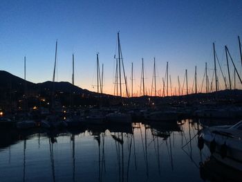 Silhouette of sailboats at harbor during sunset