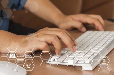 Midsection of man using laptop on table