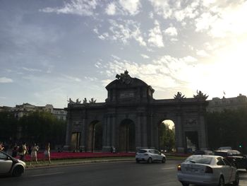 Statue in city against cloudy sky