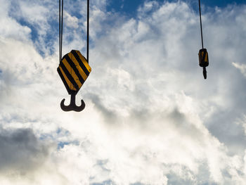 Hooks of construction crane against dramatic cloudy sky