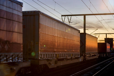 Train at railroad station against sky during sunset