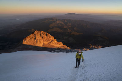 People on mountain range against sky during winter