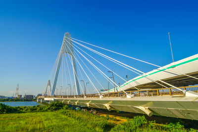 Low angle view of bridge against clear blue sky