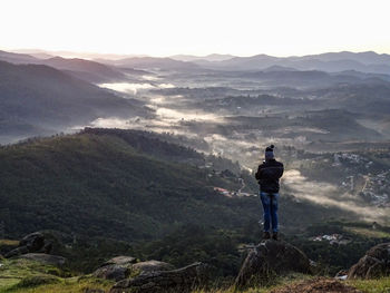 Rear view of man standing on mountain