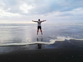 Full length of man jumping on beach