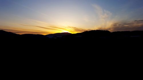 Silhouette landscape against sky during sunset