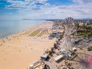 High angle view of amusement park by sea against sky