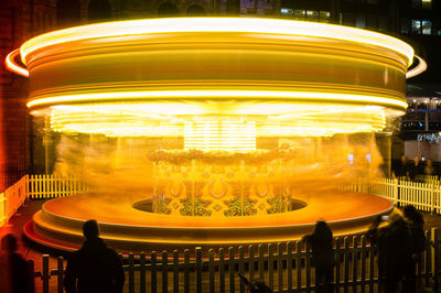 Illuminated ferris wheel in city at night