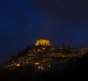 Low angle view of illuminated buildings against sky at night