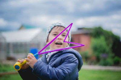 Portrait of cute boy holding bubble wand at park