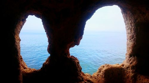 Scenic view of sea seen through cave