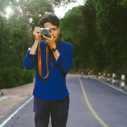 Full length of man photographing on road