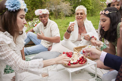 Family eating strawberry cake at picnic