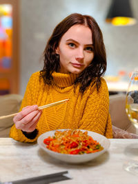 Portrait of a young woman sitting on table