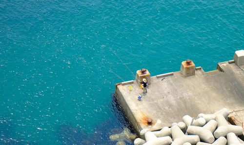 High angle view of man fishing on pier