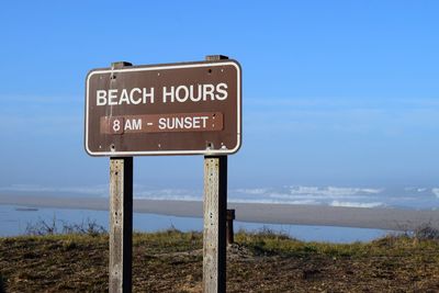 Information sign on landscape against blue sky