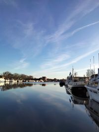 Boats moored in lake against sky