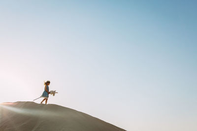 Low angle view of person standing against clear sky