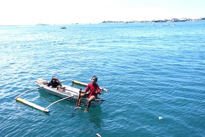 High angle view of kids on outrigger boat in sea