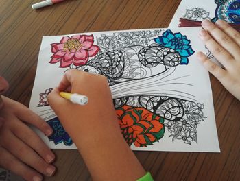 High angle view of child coloring on table