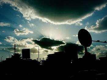 Low angle view of silhouette communications tower against sky