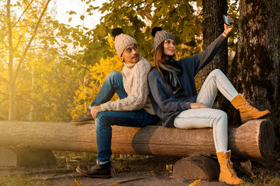 Couple taking selfie in forest during autumn